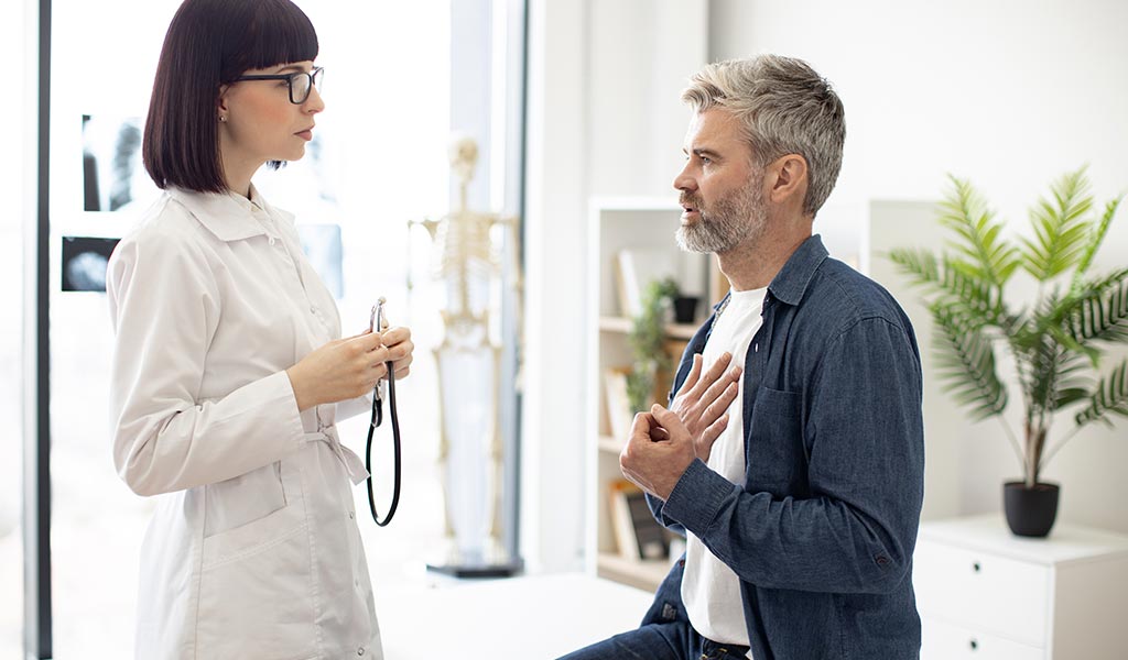 Patient spricht mit Facharzt über Brustschmerzen