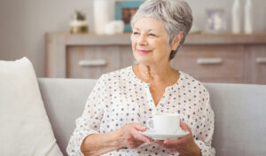 frau trinkt kaffee auf sofa