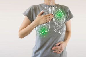 Person, die Brust und Bauch berührt, mit dargestellten Lungen und grünen Markierungen auf ihrem Hemd.